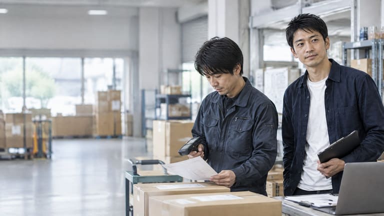 明るい制作スペースで資料を確認する二人
