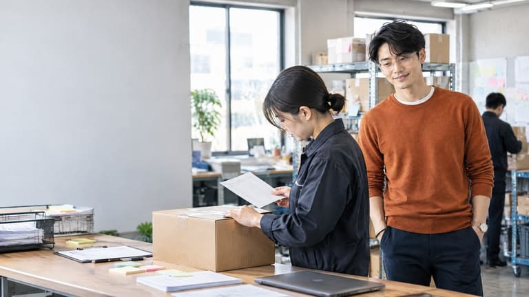 荷物の箱を囲んで確認する二人