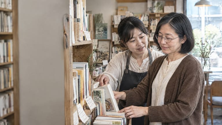 本棚のある店内で向き合って話す二人