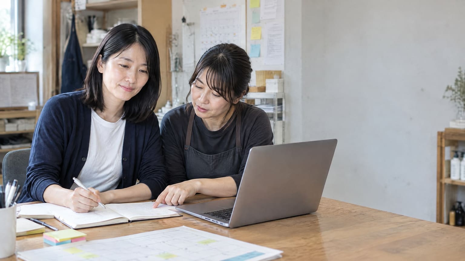 机に書類を広げ、相談する二人